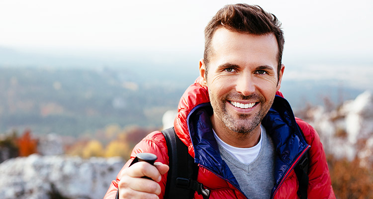 Young man hiking mountain smiling
