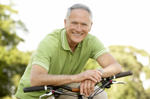 Older man riding bike after cataract surgery