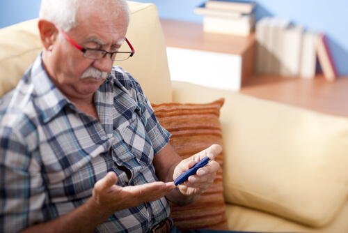 Older man with cataracts checking his blood sugar