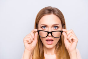 woman holding her glasses