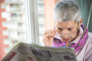 woman wearing glasses and reading newspaper 