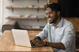 Happy young man using a laptop